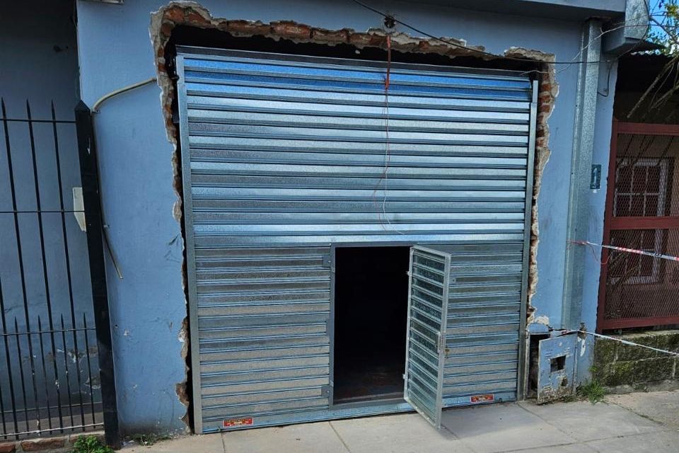 Cortina metálica con puerta peatonal colocada en un frente