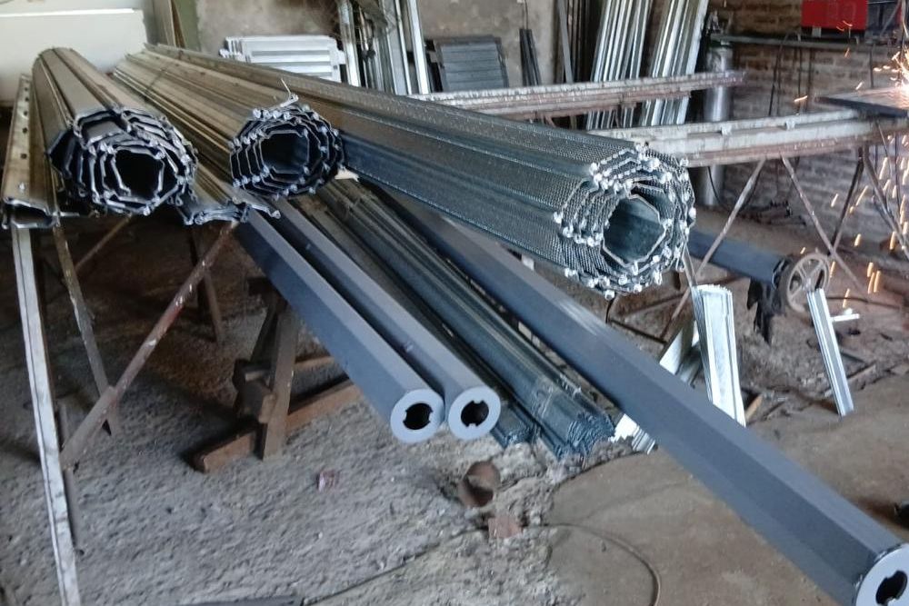 Cortinas metálicas enrolladas y tubos en el taller de fabricación